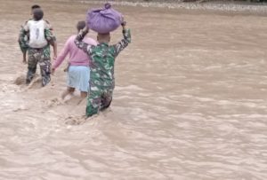 Terjebak Banjir, Satgas Yonif 132 Bantu Warga Seberangkan Kendaraan